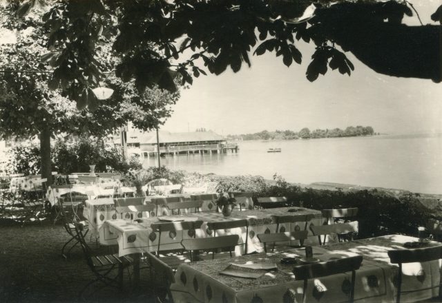 Seeansicht mit Gartenrestaurant und Badhütte im Hintergrund