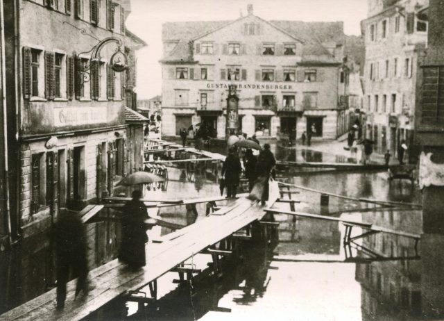 Hochwasseransicht mit Holzstegen und Passanten