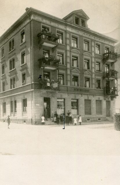 Eckansicht des Café-Restaurant Bündnerhof mit Personengruppe