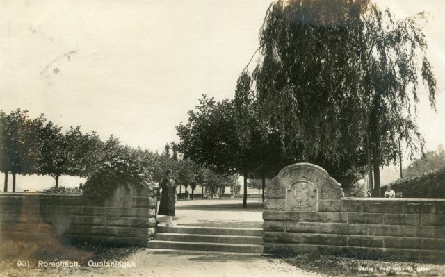 Eingang zu den Quaianlagen mit Sandsteinmauer und Reliefs