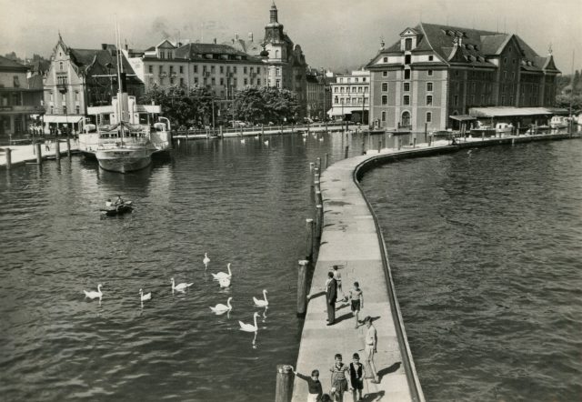 Belebte Hafenmole mit Blick auf das Kornhaus und Dampfschiff „Rhein“
