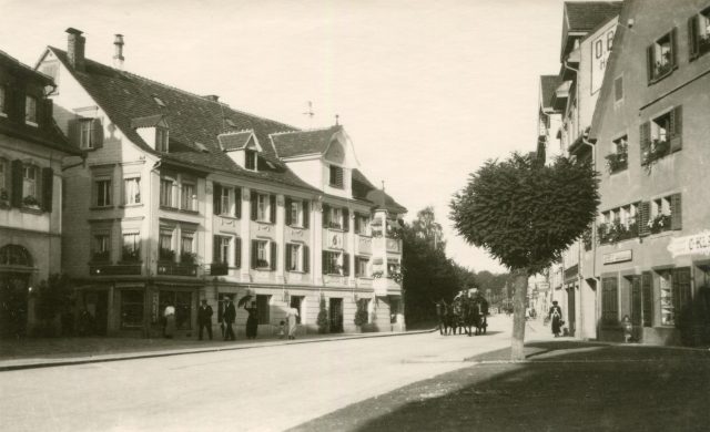 Strassenansicht mit Pferdegespann und Geschäftshäusern