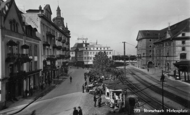 Belebter Hafenplatz mit Kiosken und Blick zum Hotel Schiff