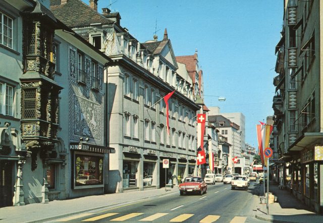 Hauptstrasse mit dem Kino Eden, historischem Erker und 1970er-Verkehr