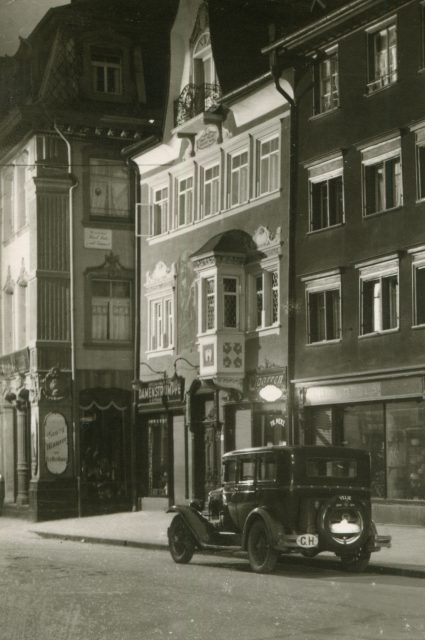 Strassenansicht mit Automobil, Erkerfassade und Ladenzeile