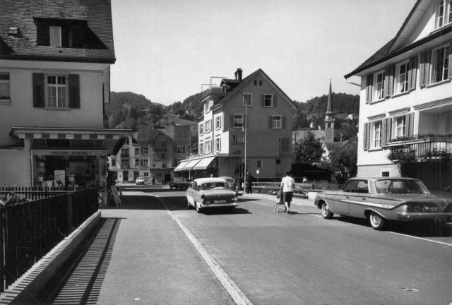 Strassenszene an der Grenzstrasse mit Früchteladen und klassischen Automobilen