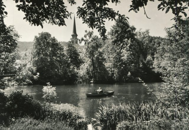 Romantischer Blick über den Chäsiweiher mit Ruderer und katholischer Kirche